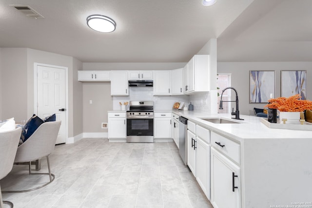 kitchen featuring visible vents, appliances with stainless steel finishes, light countertops, under cabinet range hood, and a sink