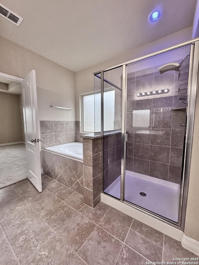 bathroom with visible vents, a shower stall, and a bath