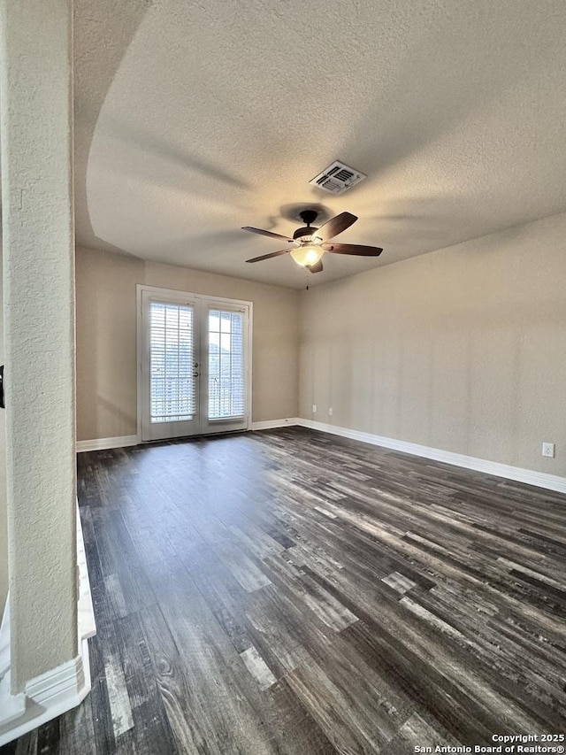 spare room with baseboards, visible vents, ceiling fan, dark wood-type flooring, and french doors