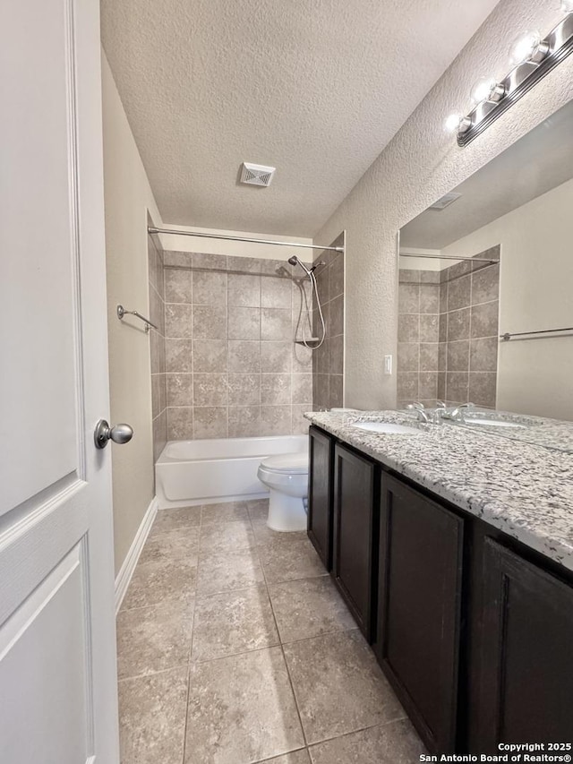 bathroom with a textured ceiling, toilet, visible vents, vanity, and washtub / shower combination