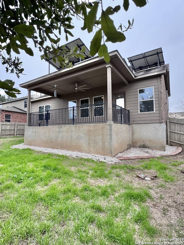 rear view of house featuring a yard and fence