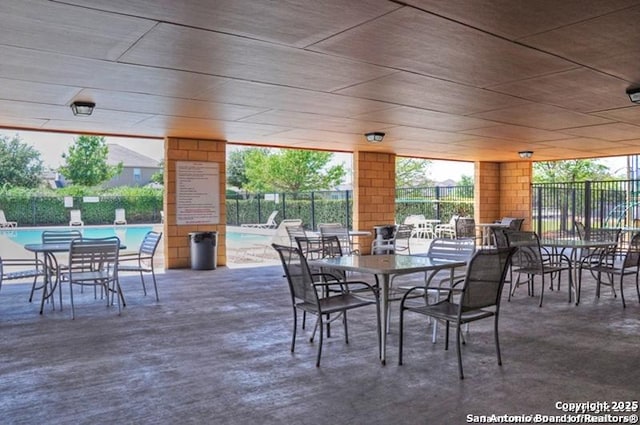 view of patio / terrace featuring fence and a community pool