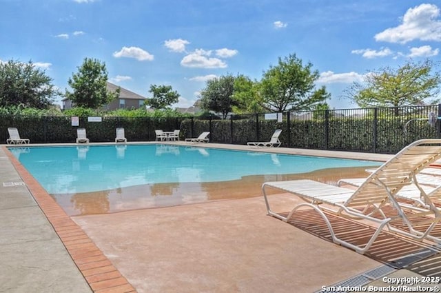 community pool featuring a patio area and fence