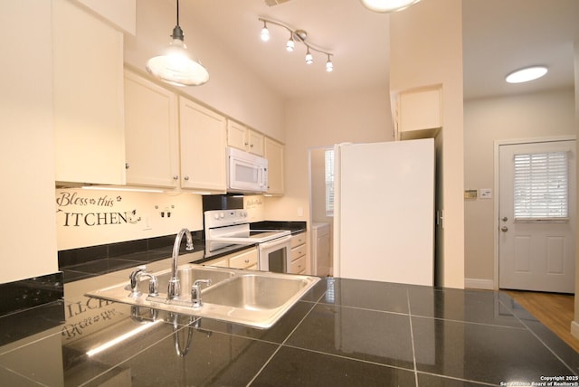 kitchen with tile counters, hanging light fixtures, white cabinetry, a sink, and white appliances