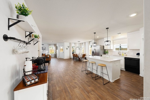 kitchen featuring dishwasher, a center island, white cabinetry, and stainless steel fridge with ice dispenser