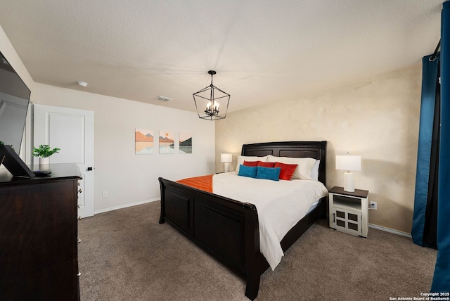 bedroom with a chandelier, dark colored carpet, visible vents, and baseboards