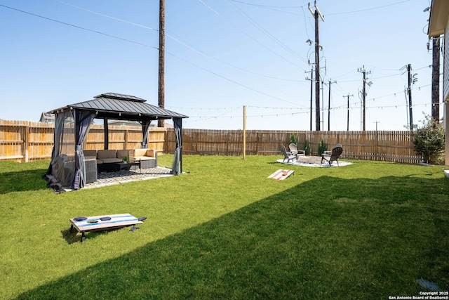 view of yard with an outdoor living space with a fire pit, a fenced backyard, and a gazebo