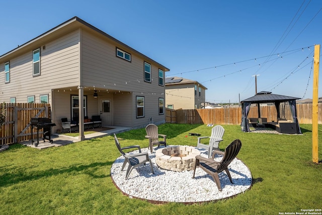 rear view of house featuring an outdoor fire pit, a patio, a fenced backyard, a gazebo, and a yard