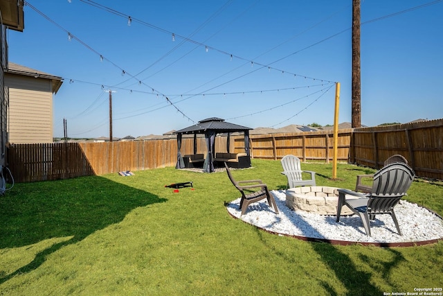 view of yard with a fenced backyard, a fire pit, and a gazebo