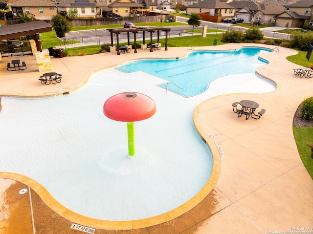 pool with a residential view, a patio area, and fence