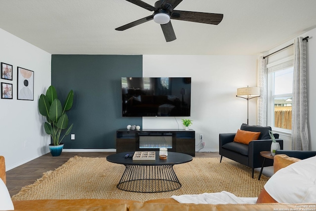 living room featuring a ceiling fan, baseboards, and wood finished floors