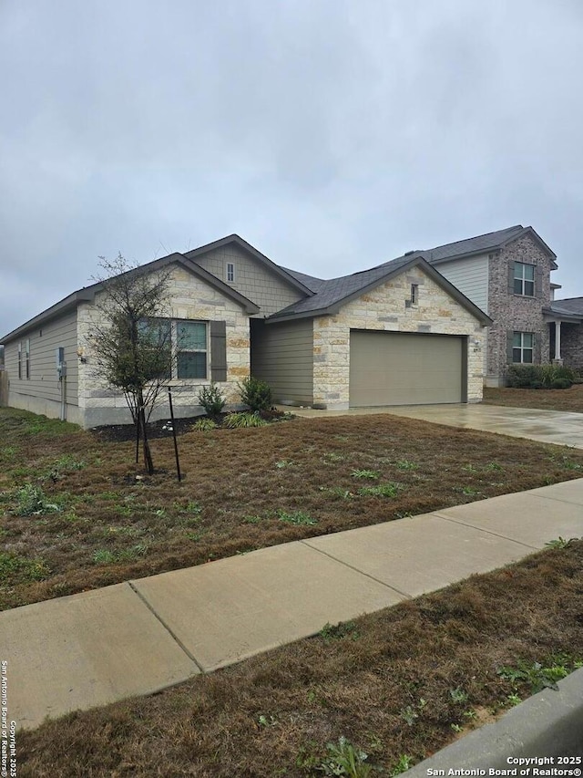 view of front of home featuring stone siding, driveway, and an attached garage