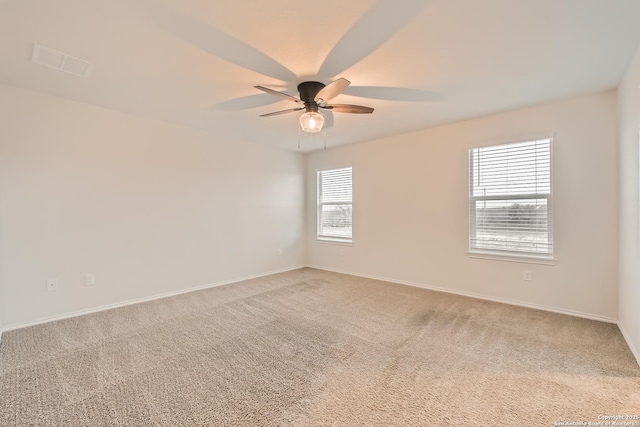 carpeted spare room with ceiling fan and baseboards