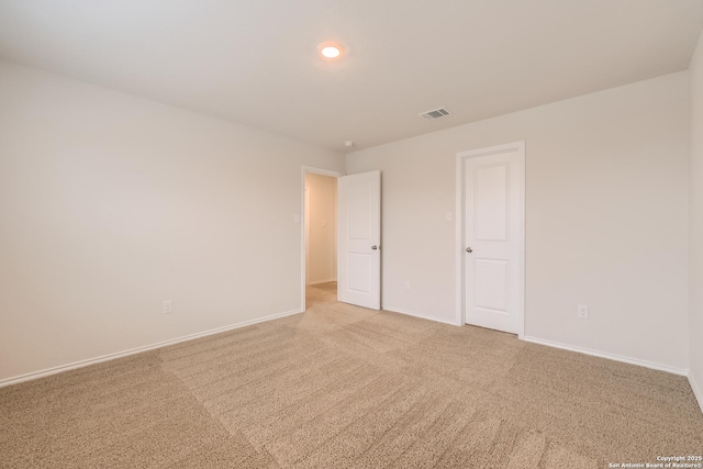 unfurnished bedroom featuring light colored carpet, visible vents, and baseboards