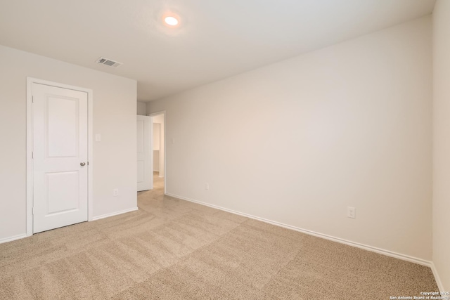 unfurnished room featuring light carpet, visible vents, and baseboards