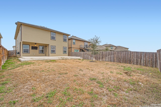 rear view of property with a patio, a yard, and a fenced backyard