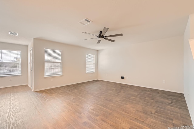 empty room featuring visible vents, plenty of natural light, and wood finished floors