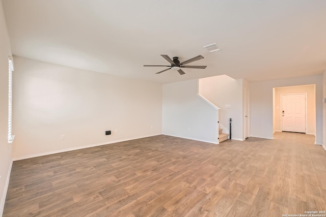 additional living space with visible vents, baseboards, ceiling fan, stairs, and light wood-type flooring