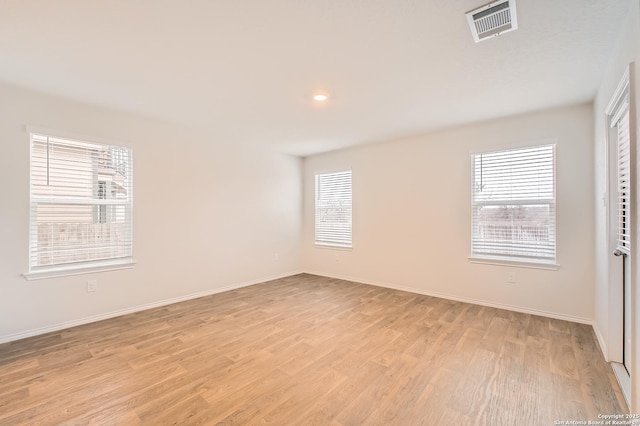 empty room with light wood-type flooring, visible vents, baseboards, and recessed lighting