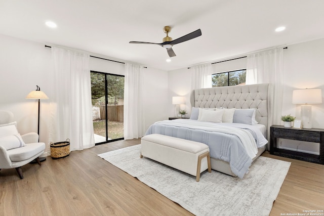 bedroom featuring light wood-style floors, access to outside, and multiple windows