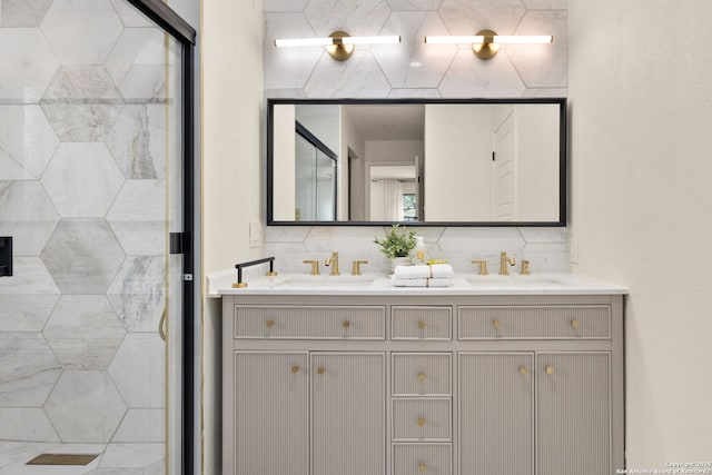 full bathroom with a sink, a shower stall, and double vanity