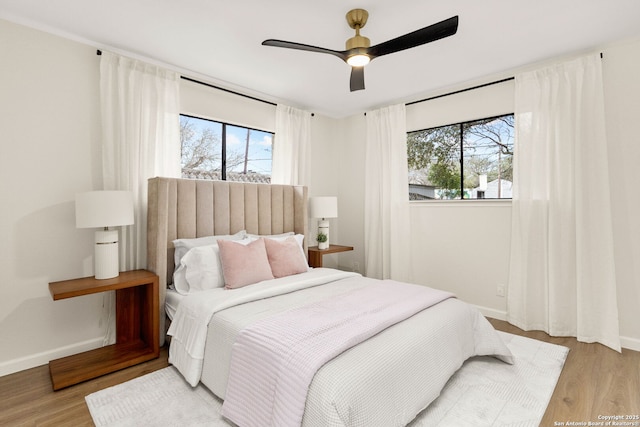 bedroom featuring light wood-type flooring, ceiling fan, and baseboards