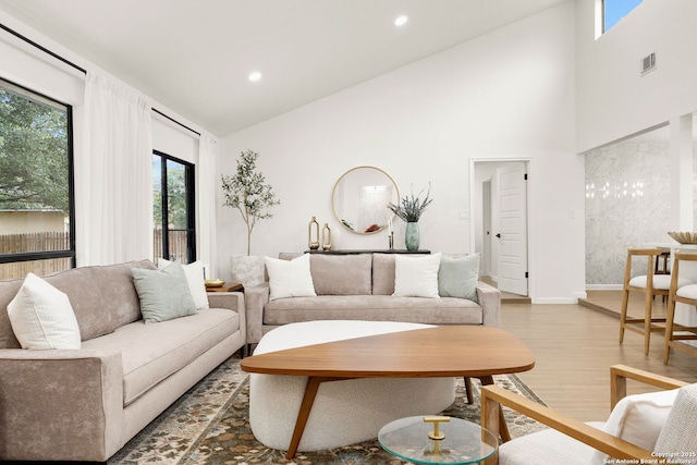 living room with recessed lighting, visible vents, wood finished floors, high vaulted ceiling, and baseboards