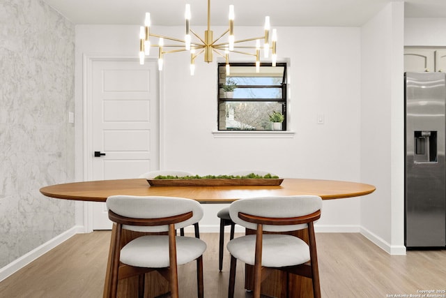 dining space with light wood-type flooring and baseboards