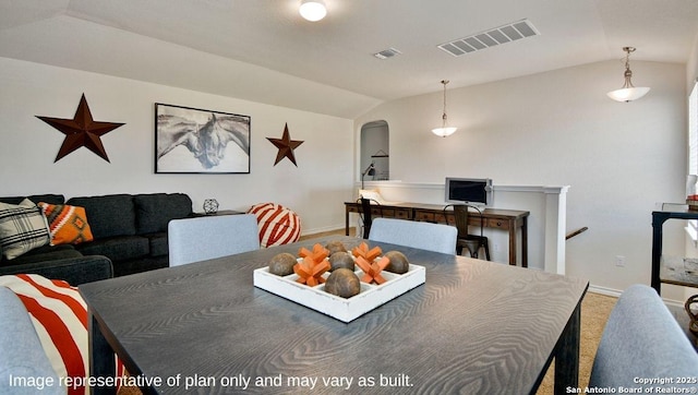 carpeted dining area with visible vents, vaulted ceiling, and baseboards