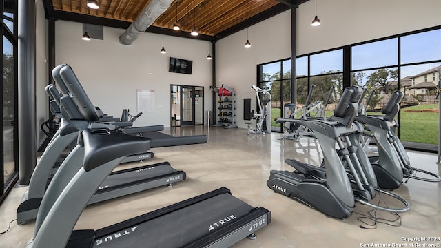 exercise room with a high ceiling and wooden ceiling