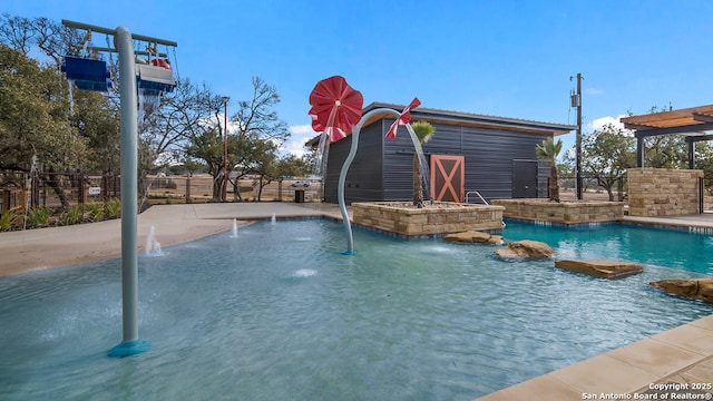 view of pool featuring fence and an outdoor structure