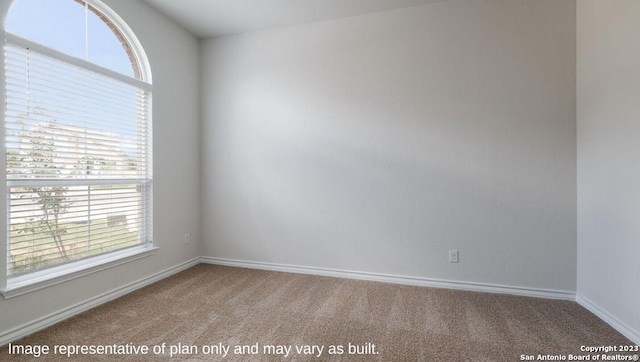 spare room featuring carpet and baseboards