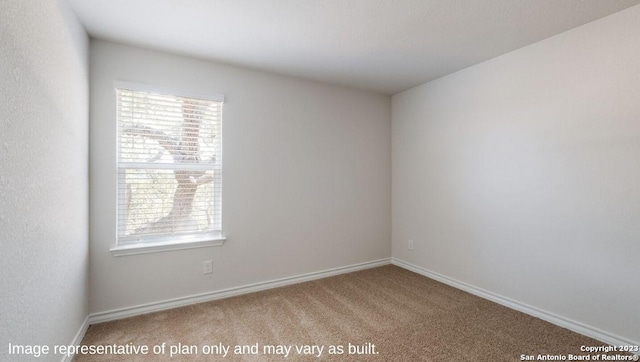 spare room featuring carpet and baseboards