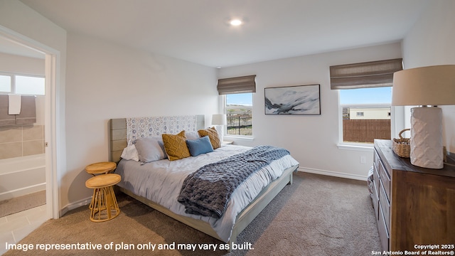 bedroom with ensuite bath, baseboards, and light colored carpet