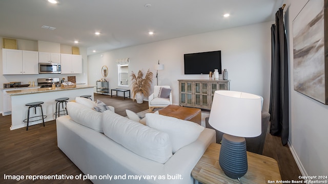 living room with baseboards, dark wood-type flooring, visible vents, and recessed lighting