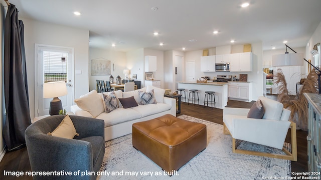 living room with light wood-type flooring and recessed lighting