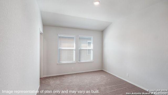 spare room featuring light colored carpet and baseboards