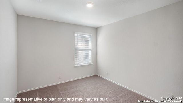 spare room with light carpet and baseboards