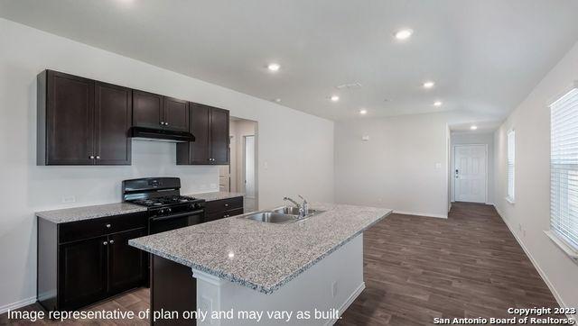 kitchen featuring recessed lighting, a kitchen island with sink, black gas stove, a sink, and under cabinet range hood