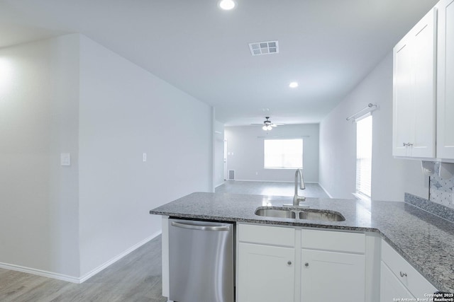 kitchen featuring a peninsula, a sink, white cabinets, dishwasher, and light wood finished floors