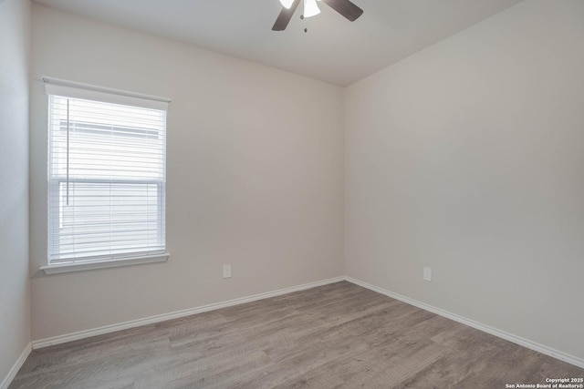 unfurnished room featuring a ceiling fan, light wood-style flooring, and baseboards