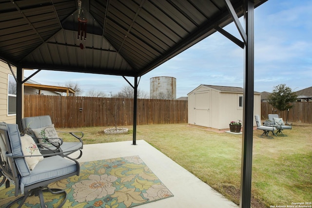 view of patio featuring a fenced backyard, a storage unit, an outdoor structure, and a gazebo