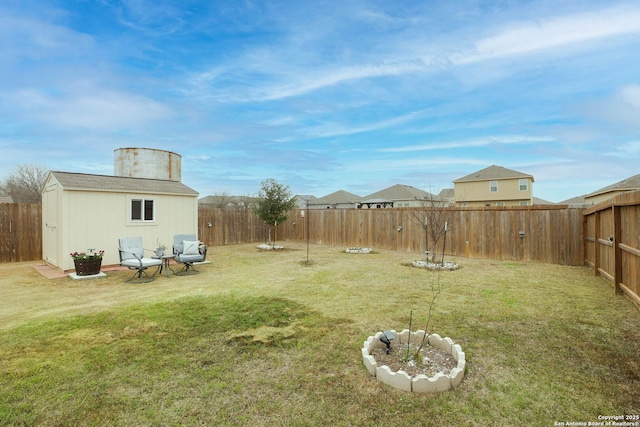 view of yard featuring an outbuilding, a fenced backyard, and a storage shed