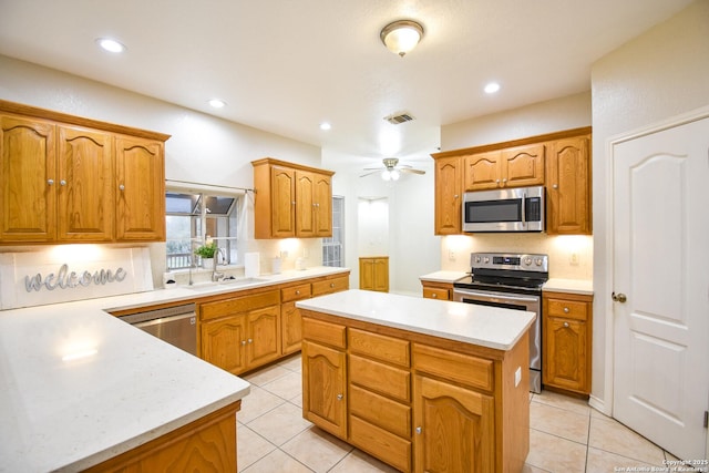 kitchen with a kitchen island, visible vents, stainless steel appliances, and light countertops