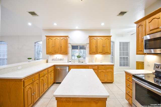 kitchen featuring light countertops, appliances with stainless steel finishes, a peninsula, and visible vents