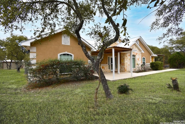 view of front of property with a front yard, stone siding, and stucco siding