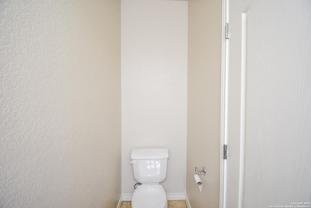 bathroom featuring toilet and baseboards