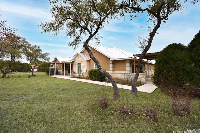 view of front of property with stone siding, a front yard, and stucco siding