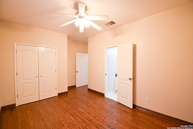 unfurnished bedroom with baseboards, visible vents, a ceiling fan, dark wood finished floors, and a closet