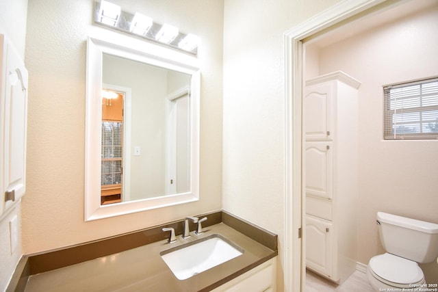 half bathroom featuring vanity and toilet